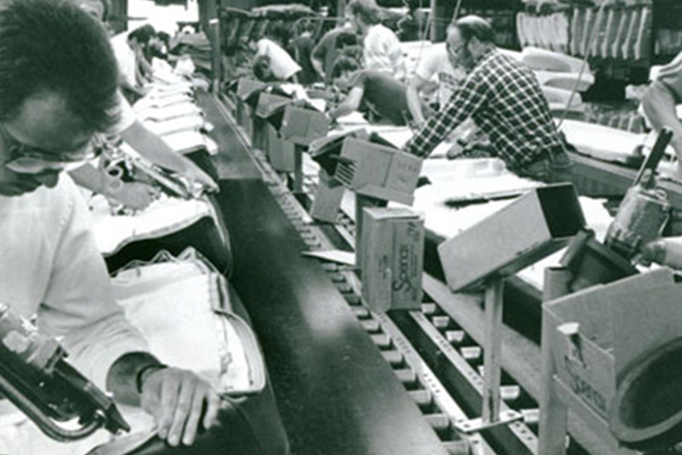 People manufacturing automotive equipment in a factory